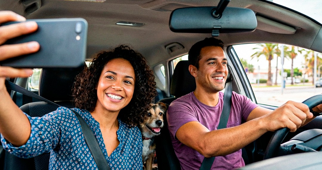 Casal com cachorro em um carro durante um passeio